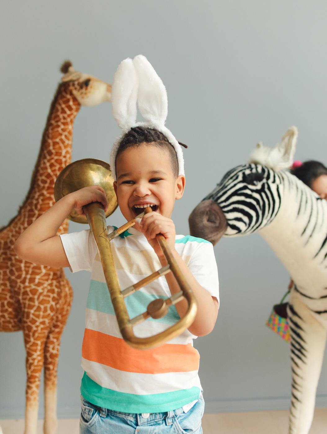 Boy with Trumpet with Animal Statues on Background